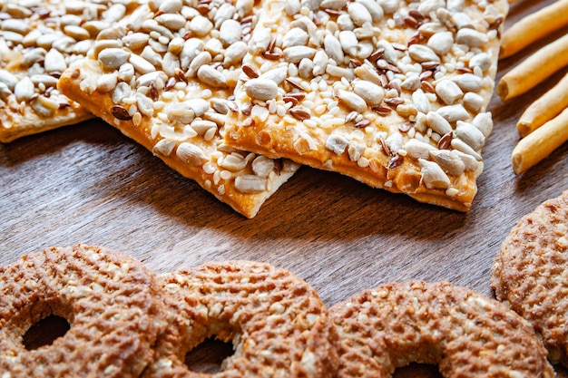 Crispy biscuit crackers with flax and sesame sunflower seeds on wooden background