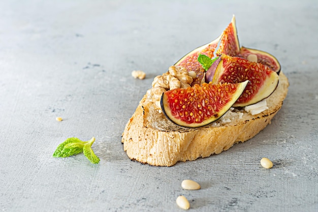 Crispy bruschetta (toast) with soft ricotta, ripe figs, walnuts and pine nuts, mint and honey