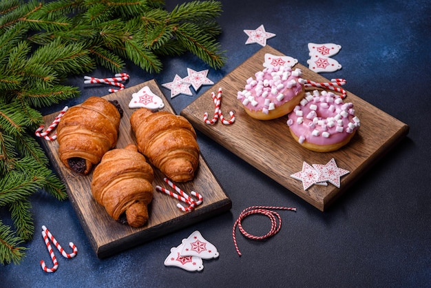 Crispy chocolate croissant with Christmas decorations on wooden cutting board