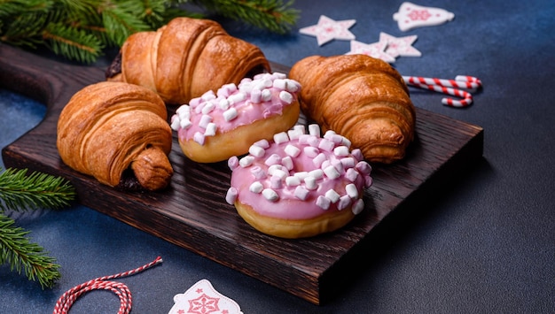 Crispy chocolate croissant with Christmas decorations on wooden cutting board