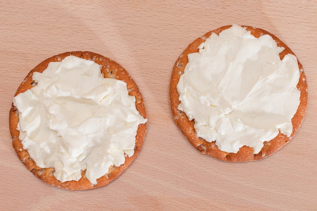 Crispy Cracker Sandwich with Cream Cheese on Wooden Board