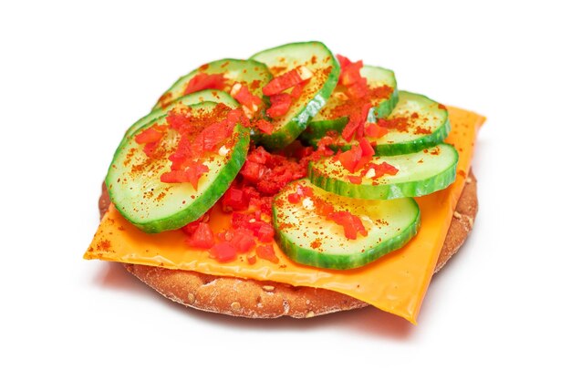 Crispy cracker sandwich with fresh cucumber cheese and paprika isolated