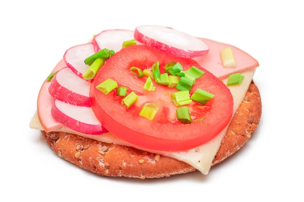 Crispy cracker sandwich with tomato sausage cheese green onions and radish isolated