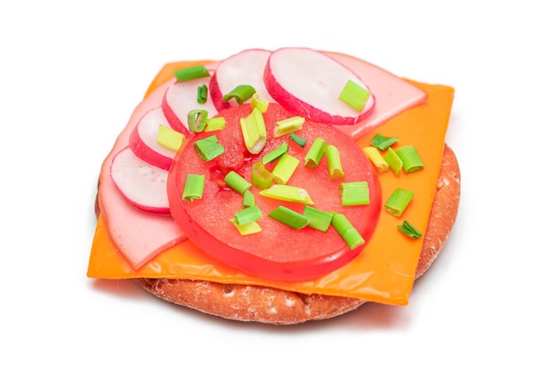 Crispy cracker sandwich with tomato sausage cheese green onions and radish isolated