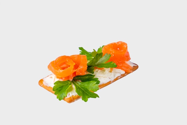 Crispy crackers with salmon and curd cheese isolated on white