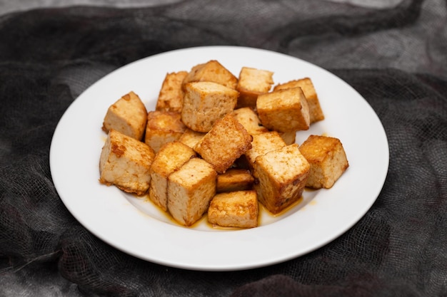 Crispy deep stir fried tofu cubes on small dish