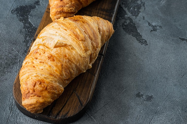 Crispy fresh croissants set, on gray stone background, with copy space for text