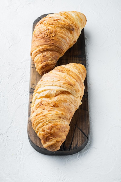 Crispy fresh croissants set, on white stone  background