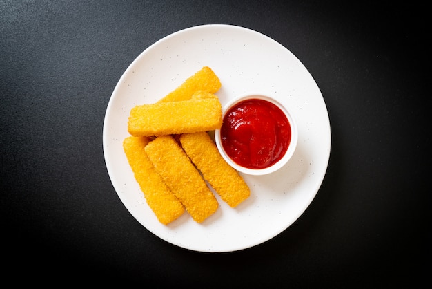 crispy fried fish fingers with breadcrumbs served on plate