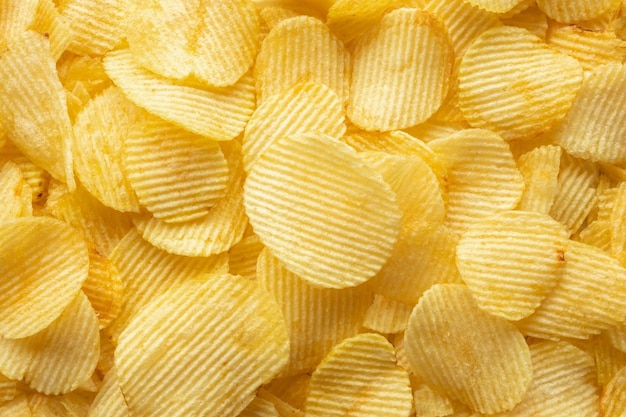 Crispy golden potato chips snack texture background