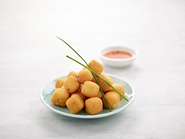 Crispy Golden Tofu with chopsticks served in a dish isolated on grey background side view