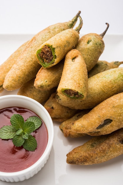 Crispy Green Chilli Pakora or Mirchi Bajji, served with tomato ketchup. Its a popular tea time snack from India especially in Monsoon. Selective focus