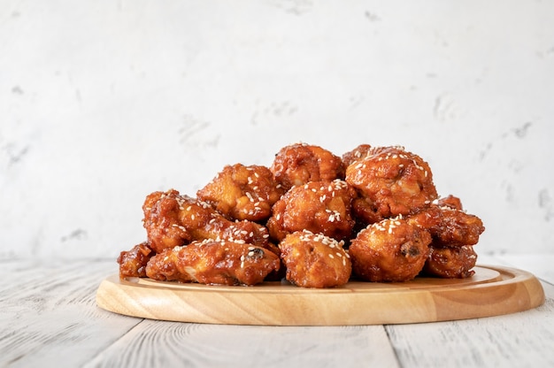 Crispy orange glazed chicken wings on the wooden board