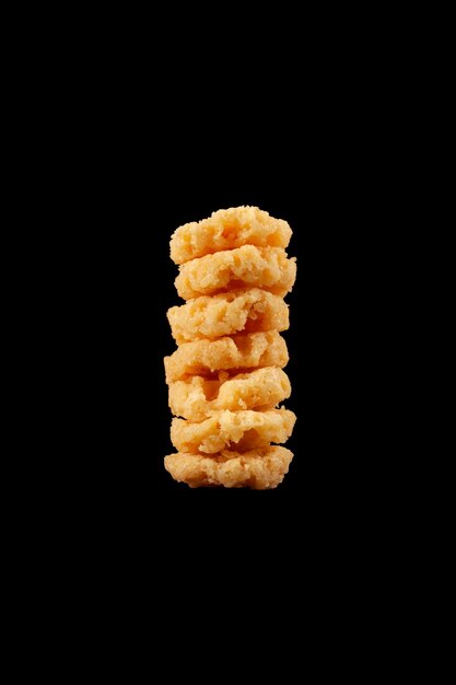 Crispy parmesan cheese chips isolated on black background Selective focus copy space Design element