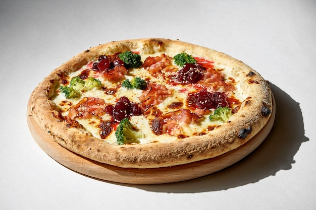 Crispy pizza with broccoli and bacon on a gray background