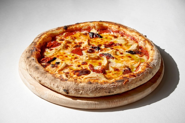 Crispy pizza with chicken and sundried tomatoes on a gray background