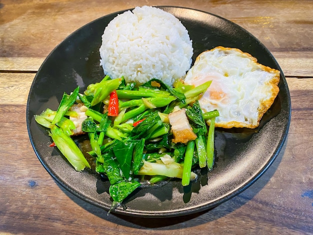 Crispy pork with Chinese broccoli and oyster sauce on rice and fried egg