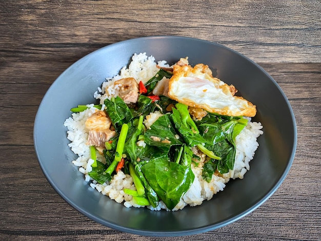 Crispy pork with Chinese broccoli and oyster sauce on rice and fried egg