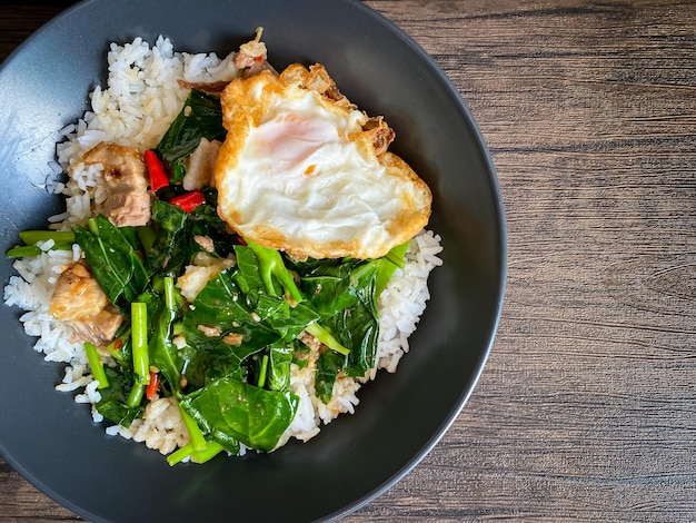 Crispy pork with Chinese broccoli and oyster sauce on rice and fried egg