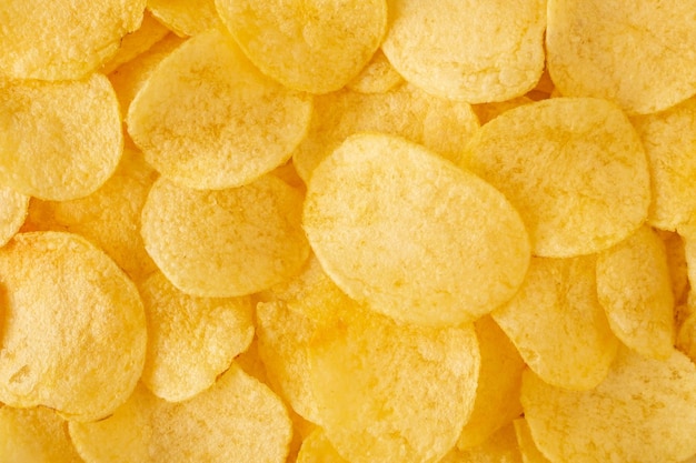 Crispy potato chips snack texture background top view