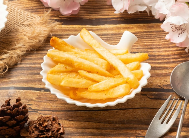 Crispy potato fries french fries in dish side view on wooden table taiwan style food