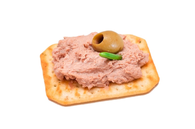 Crispy salted cracker with liver pate and olives isolated