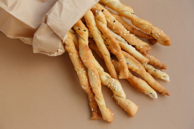 Crispy snack in paper bag Salty sesame bread sticks for quick bite