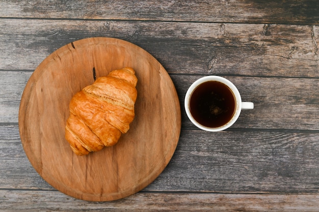 Croissant and a cup of coffee on the table. Fresh french croissant. Morning breakfast with a croissant. French breakfast Excellent homemade. Fresh tower.