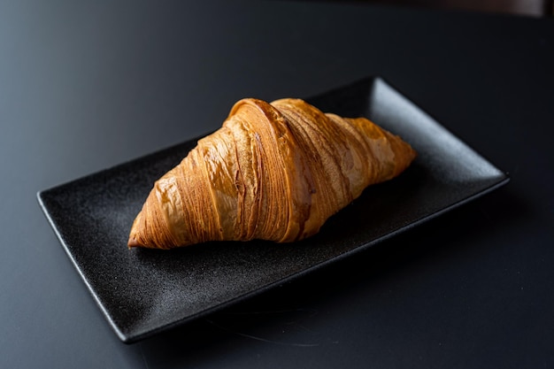 Croissant and a cup of tea on a neutral background selective focus