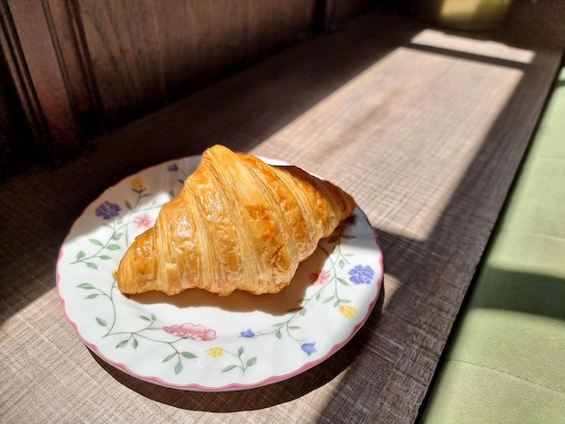 The croissant is on a ceramic plate