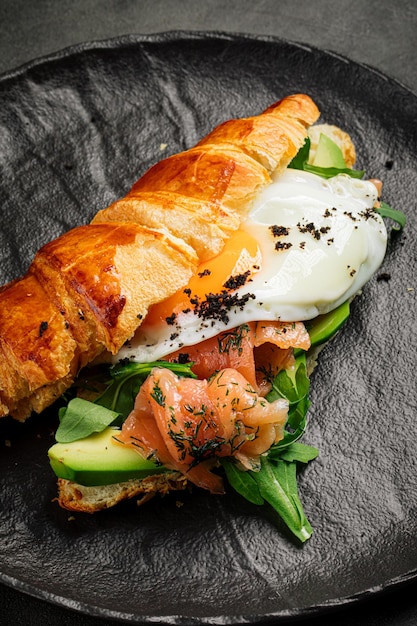 Croissant sandwich breakfast with egg and salmon