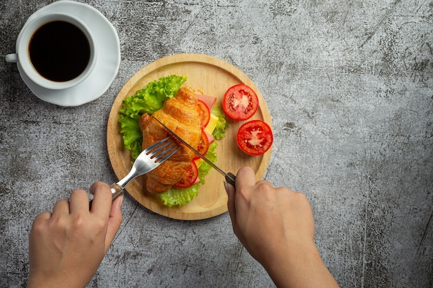 Croissant sandwiches on dark wooden surface