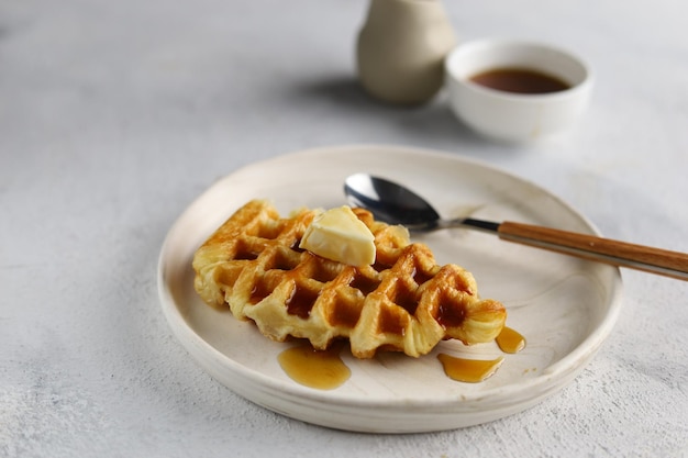 Croissant Waffle or croffle in white plate with butter and honey