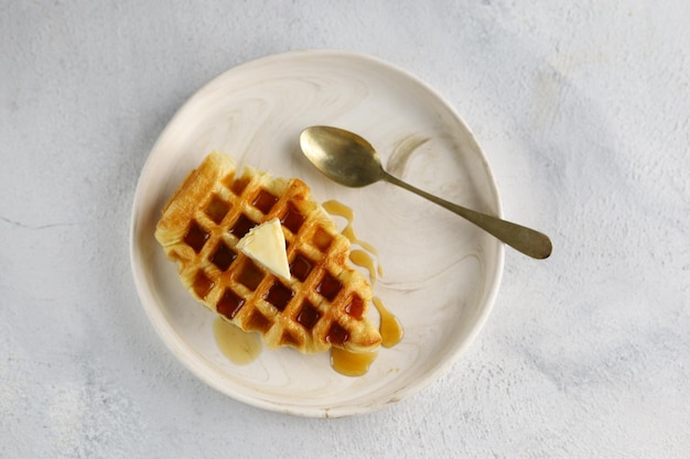 Croissant Waffle or croffle in white plate with butter and honey