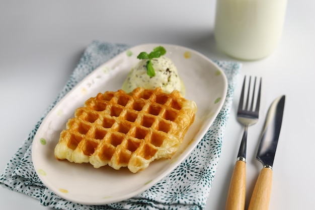 Croissant Waffle or Croffle with avocado ice cream served in the oval plate with spoon and fork