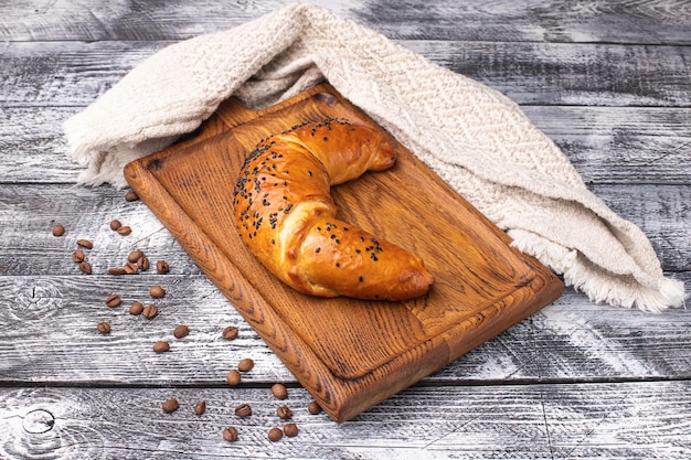 Croissant on a white wooden background wooden plate