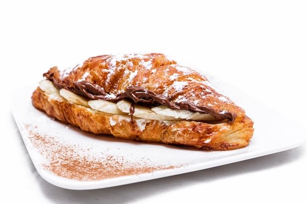 Croissant with chocolate butter and banana isolated on a white background