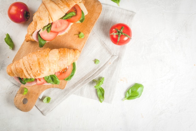 Croissant with ham, cheese, fresh tomatoes and basil