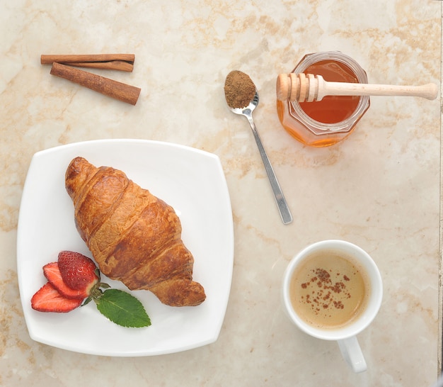 Croissant with strawberry, honey and cinnamon tea