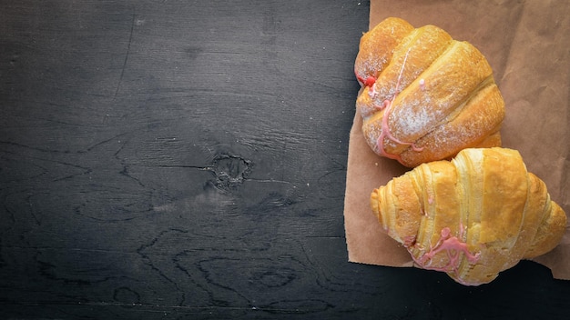 Croissant with yogurt Pastry dough On a black wooden background Free space for text  Top view