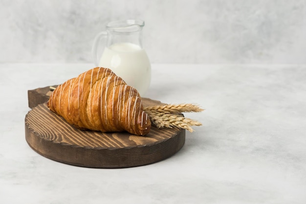 Croissant on wood plate with milk composition white background for breakfast