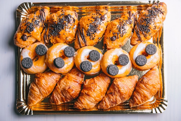 Croissants and chocolate donuts for breakfast top view of sweet snacks on table