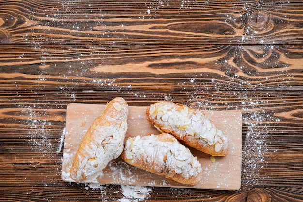 Croissants with almonds and tea on a wooden table