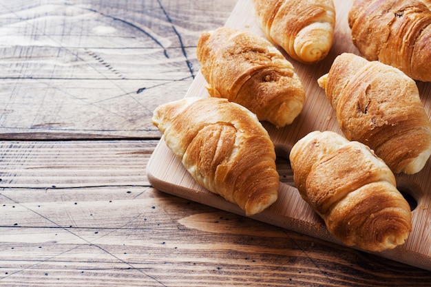 Croissants with chocolate filling on wooden background. Copy space.