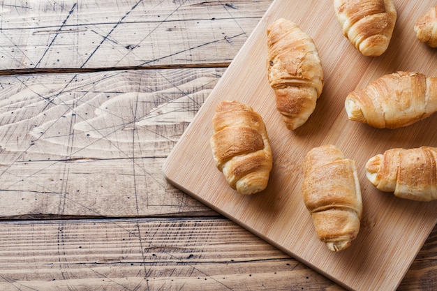 Croissants with chocolate filling on wooden background. 