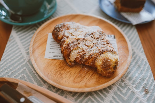 Croissants with nuts flakes crumbs and coffee on the table in the cafe Delicious breakfast morning Cafe tone color Selective focus