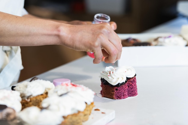 Photo crop baker decorating velvet cake with cream