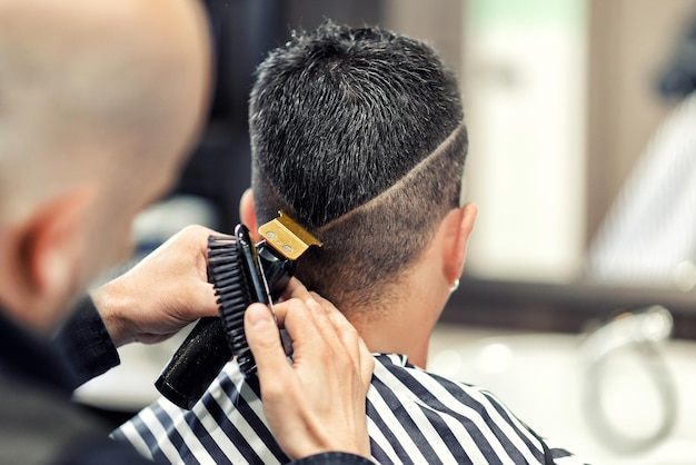 Crop barber trimming hair of client