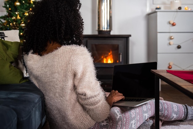 Crop black woman working on laptop