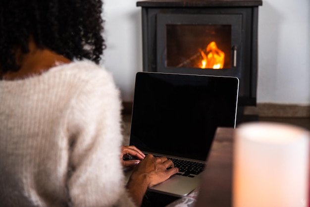 Crop black woman working on laptop